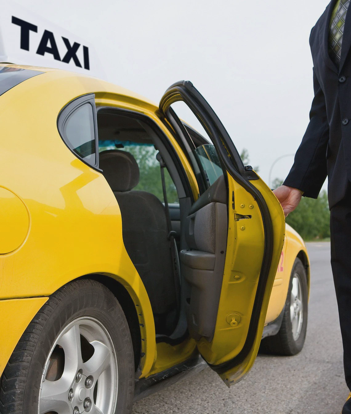 Biznesmen trzymający drzwi od taksówki